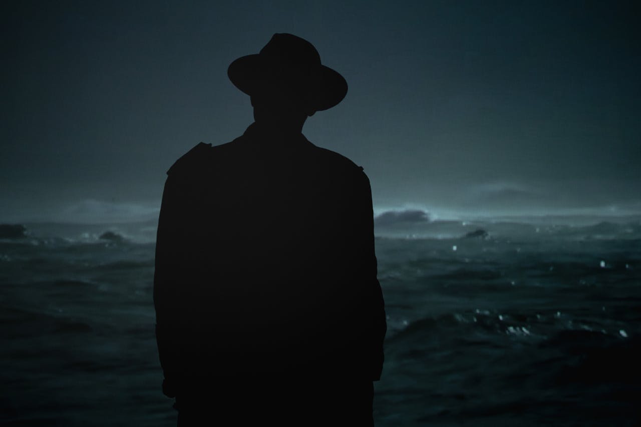 Silhouette of man wearing hat during night time