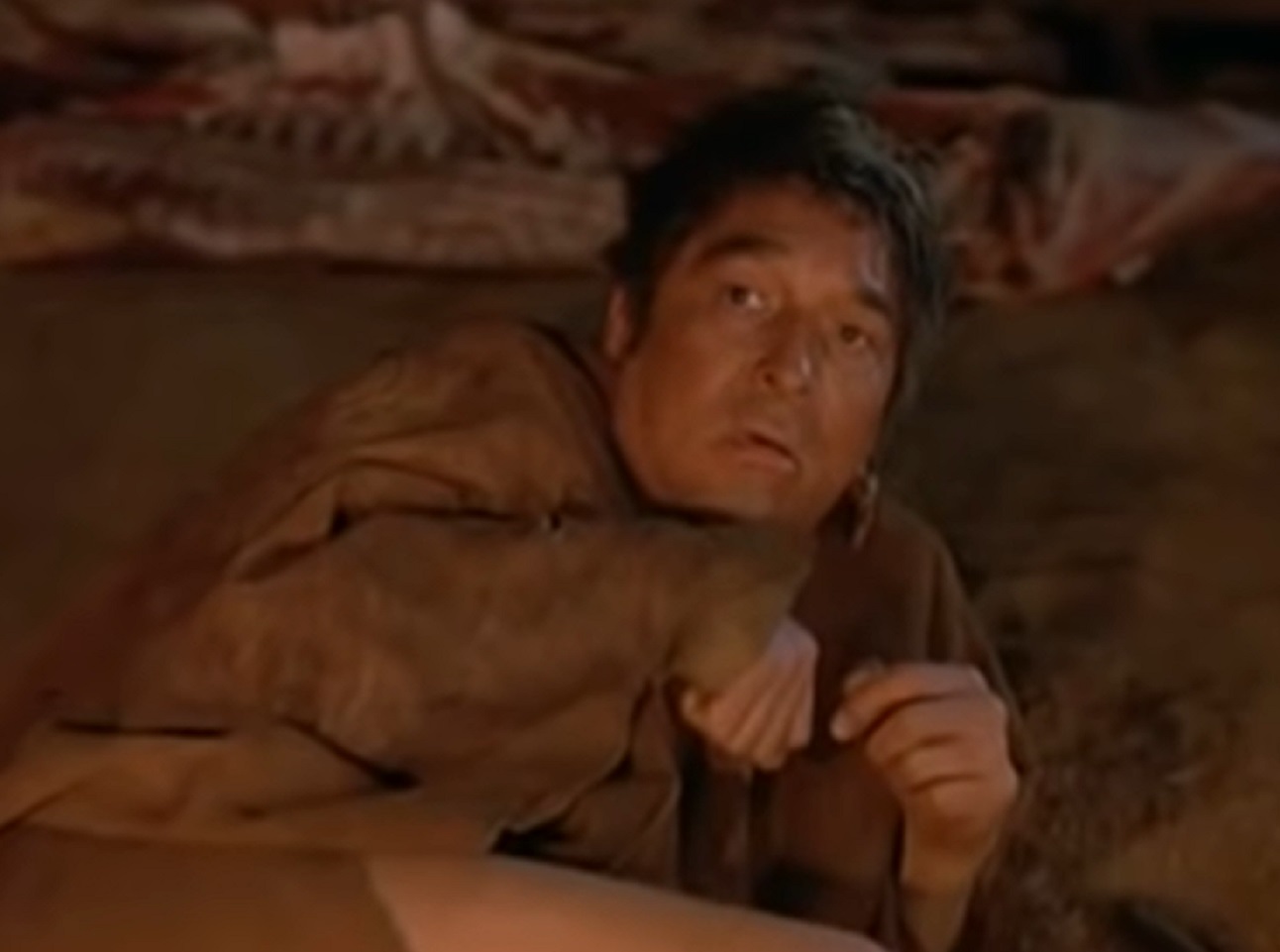 Screenshot of Ishi laying on the floor scared - from The Last of His Tribe (1992)