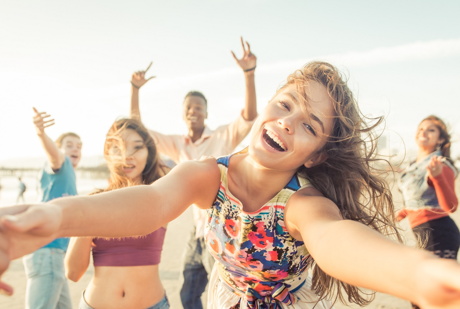 Group of friends having fun and dancing on the beach.