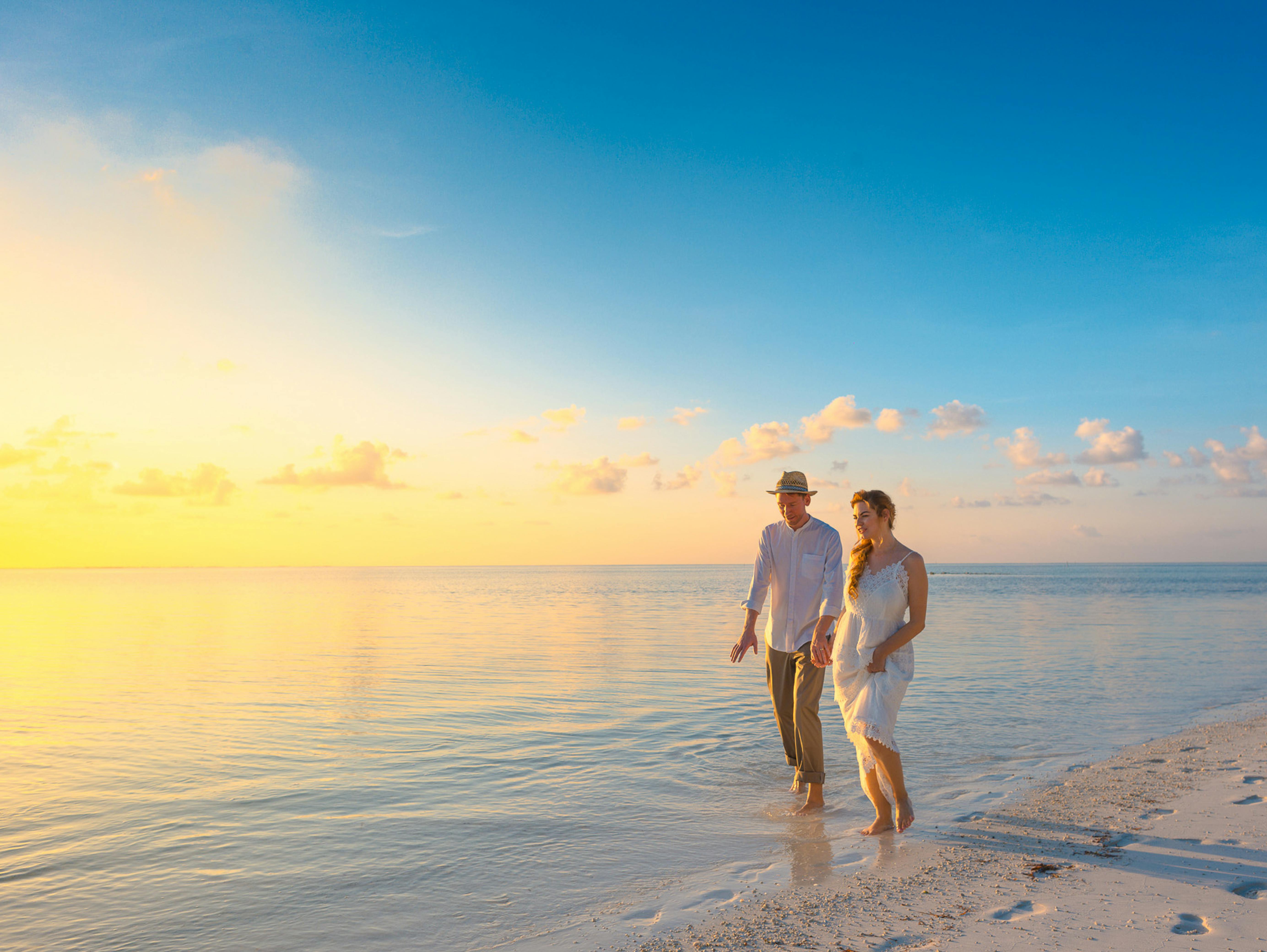 Couple Walking on Seashore during Sunset