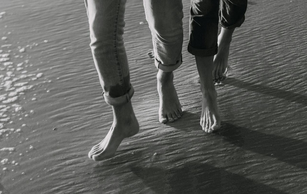 Bare Feet of People Walking on a Beach