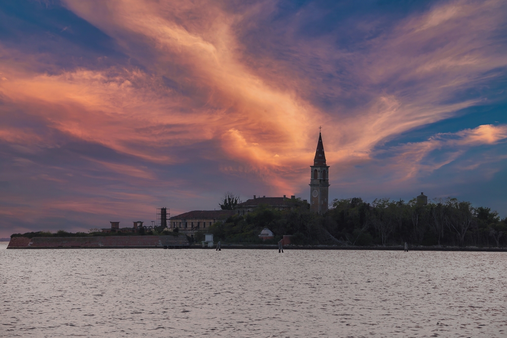 A serene dusk scene of Poveglia uninhabited island in the middle of a body of water