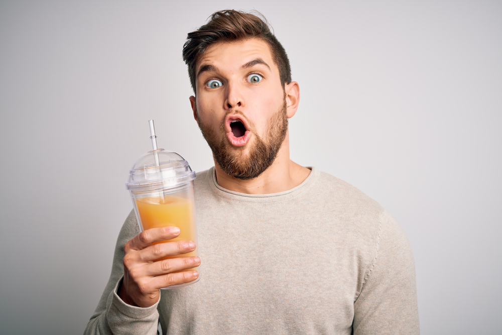 Shocked man drinking juice