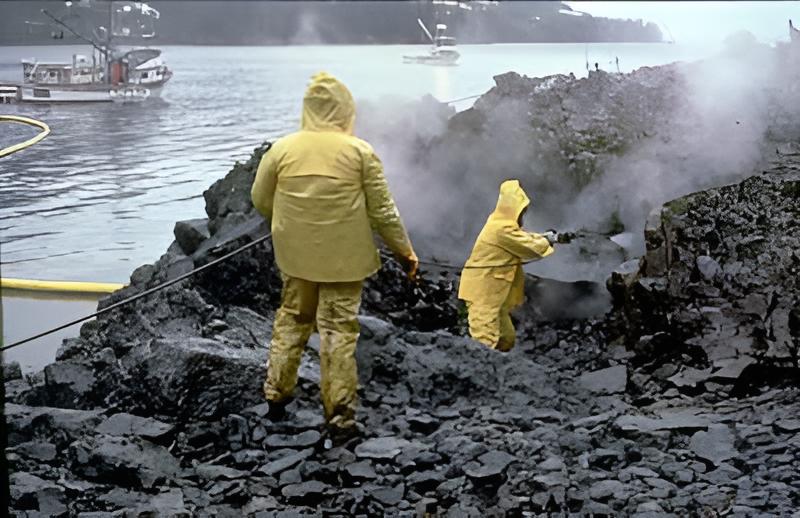 Workers using high-pressure, hot-water washing to clean an oiled shoreline after the Exxon Valdez oil spill