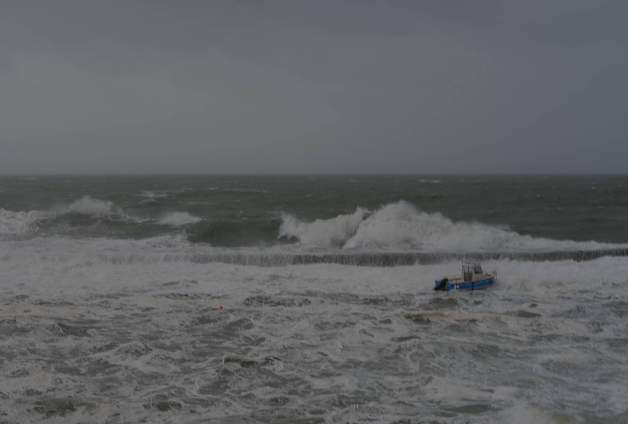 small boat surrounded by waves during storm