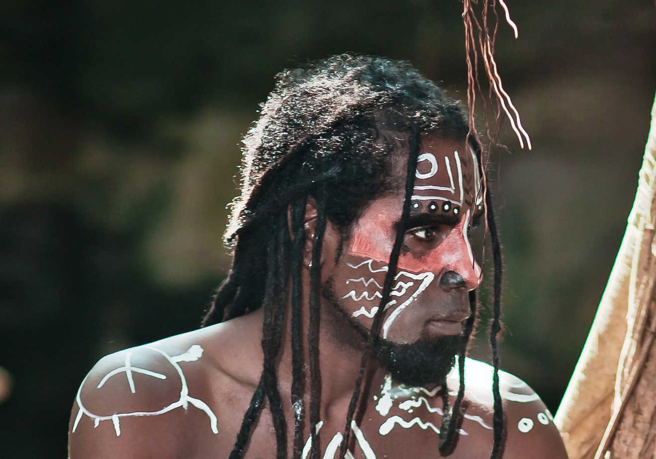 Black man with dreadlocks in the image of the Taino Indian in habitat, body painting Taino symbols