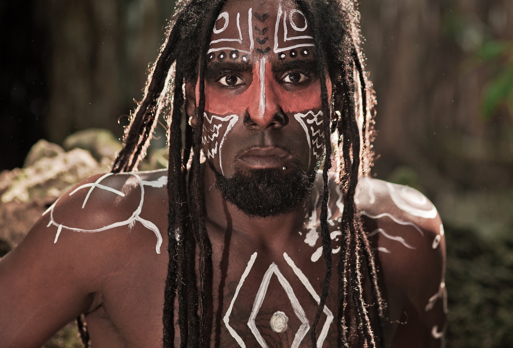 Black man with dreadlocks in the image of the Taino Indian in habitat, body painting Taino symbols