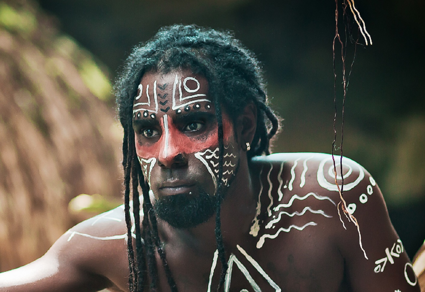 Black man with dreadlocks in the image of the Taino Indian in habitat, body painting Taino symbols