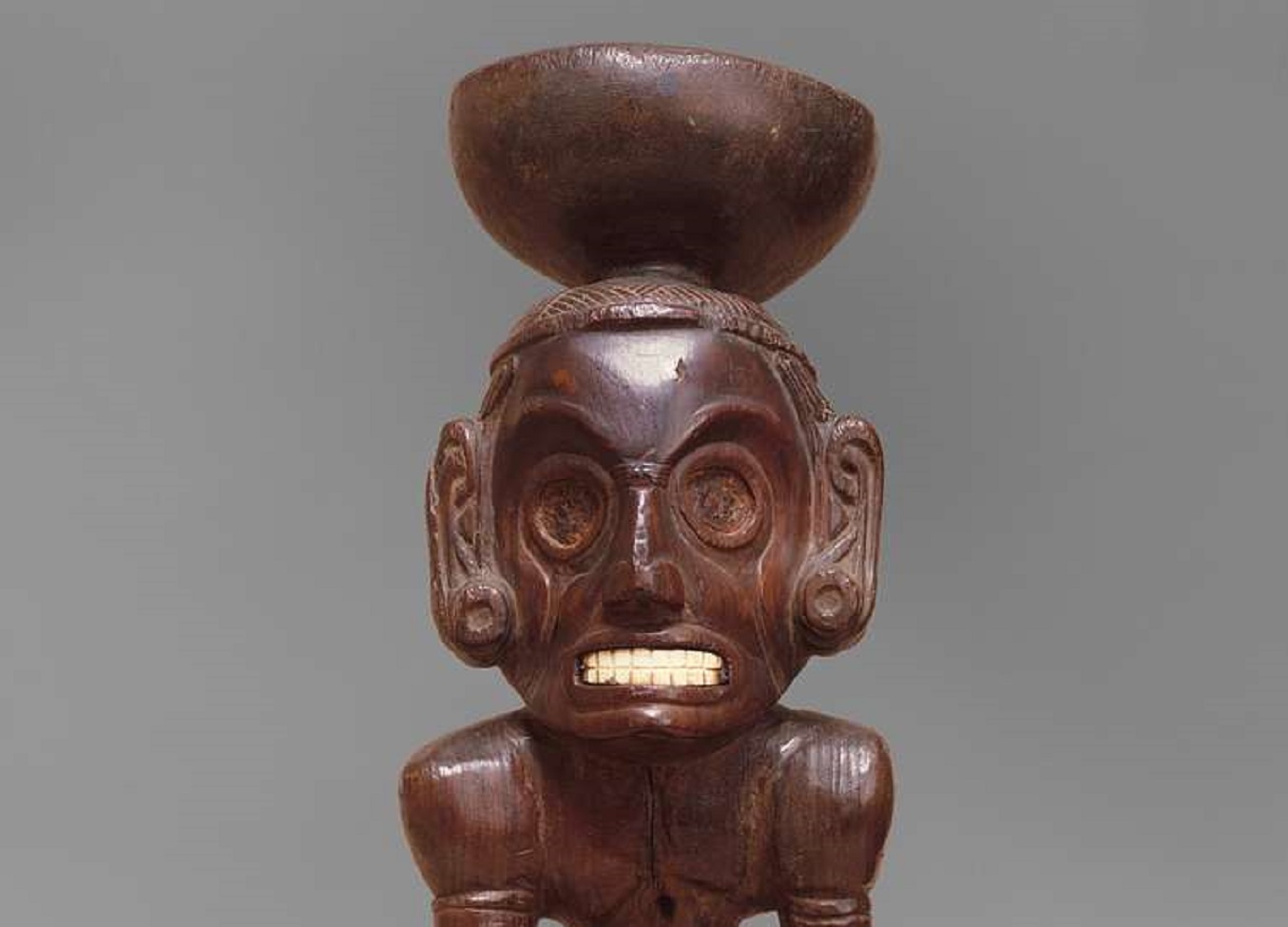 Zemí - A wooden statue of a man with a bowl on his head.
