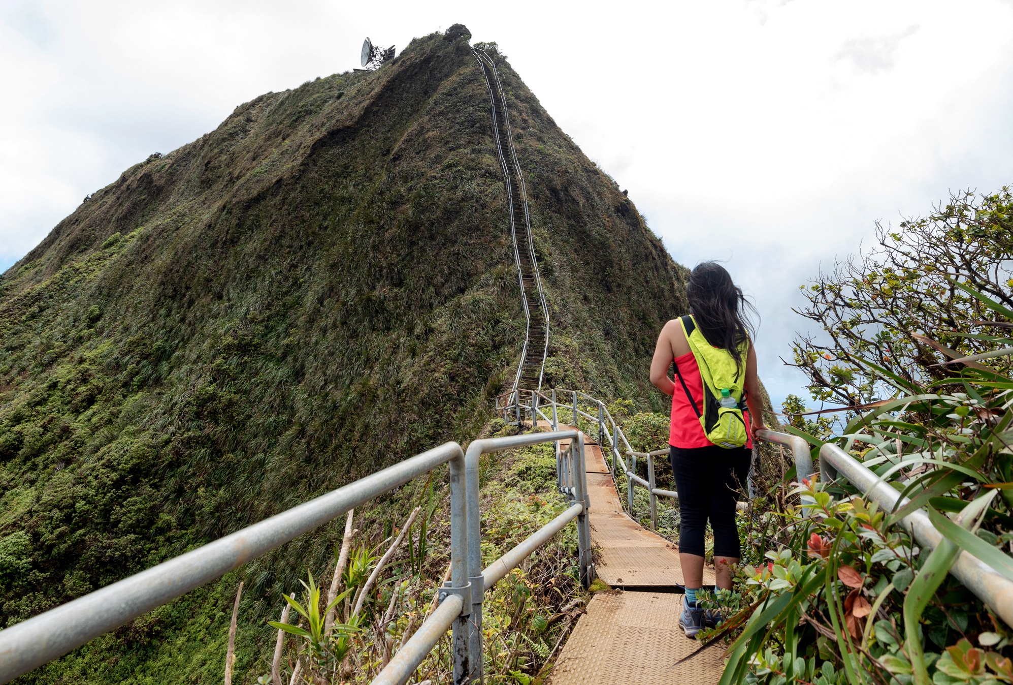 Hiker on a lush a ridge trail on Oahu,