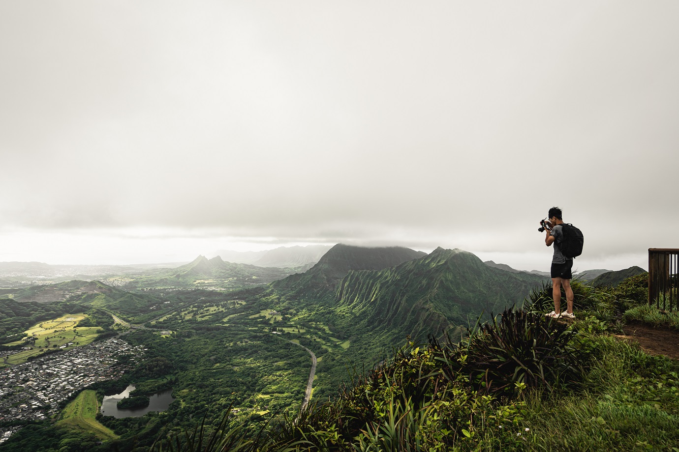 Guy takes photos at the top of the Stairway to Heaven (Haiku Stairs) hike. Oahu, Hawaii.