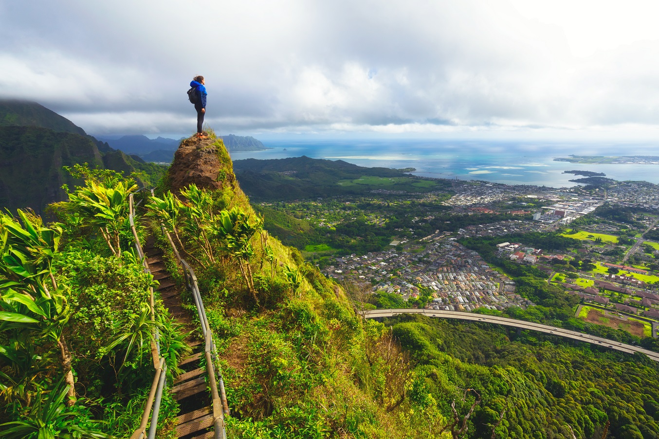 Woman standing on the peak of a mountain on the Haiku Stairway to Heaven in Hawaii