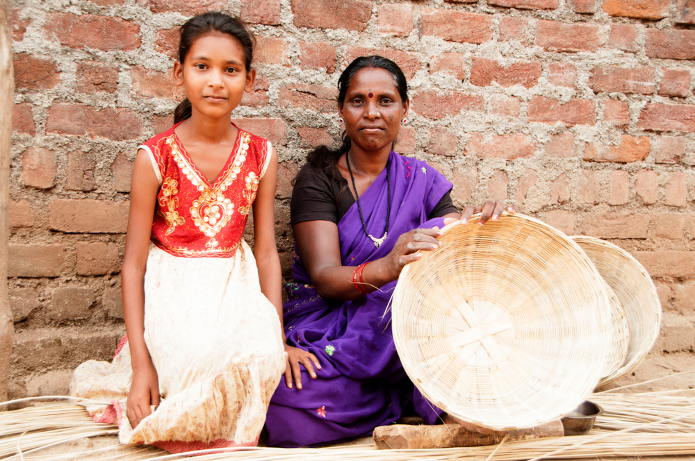 Unidentified rural woman making basket and her daughter