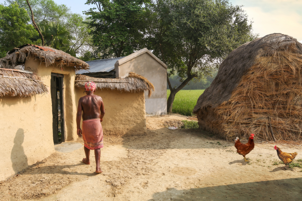 tribal man entering his mud hut in India