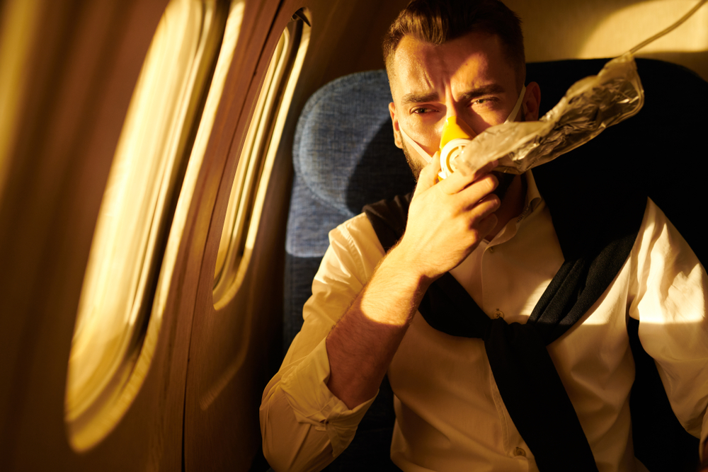 man wearing oxygen mask in plane