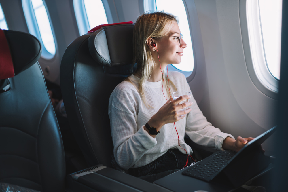 Woman drinking water on plane