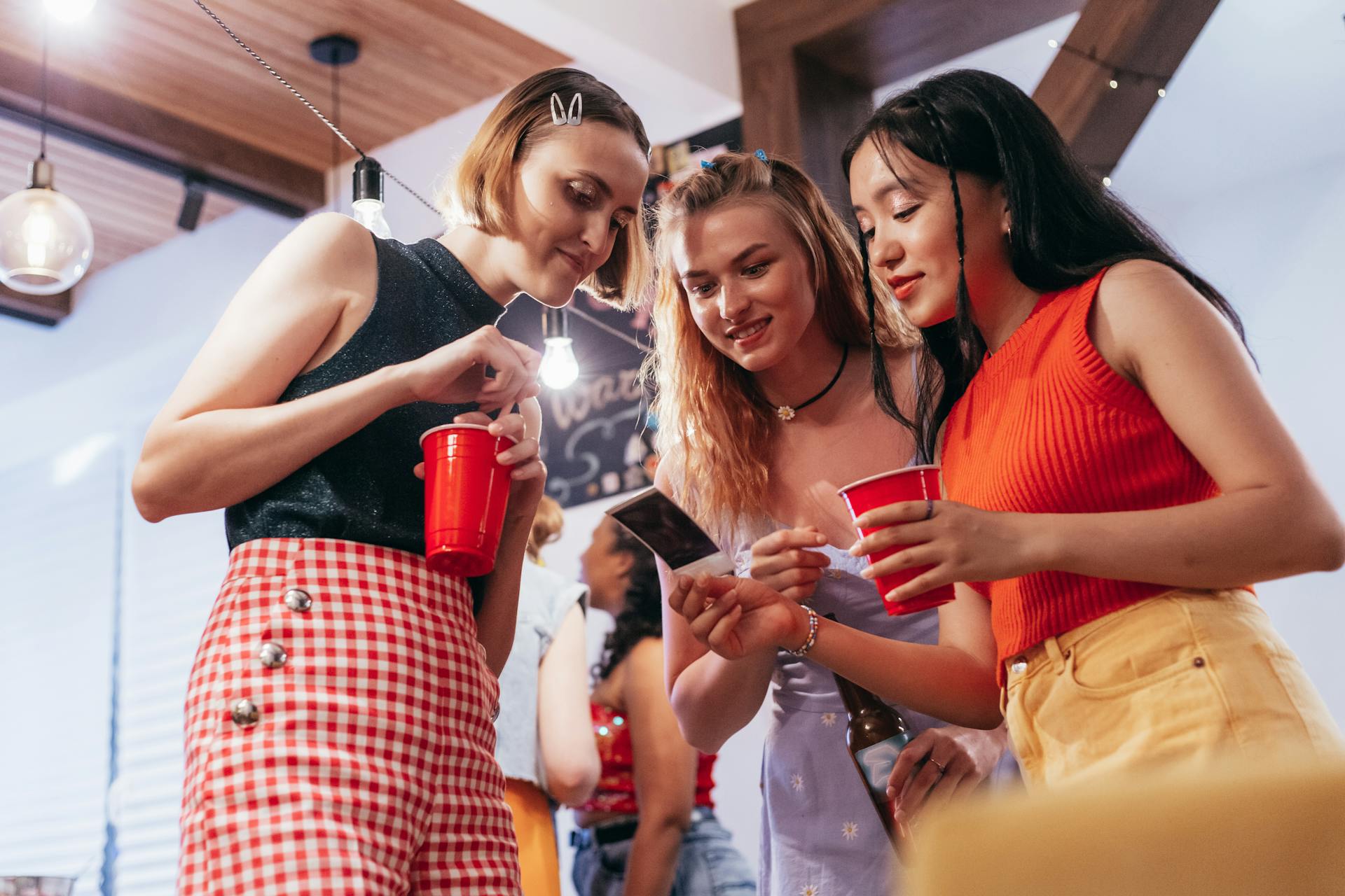 group of girls holding red plastic cups