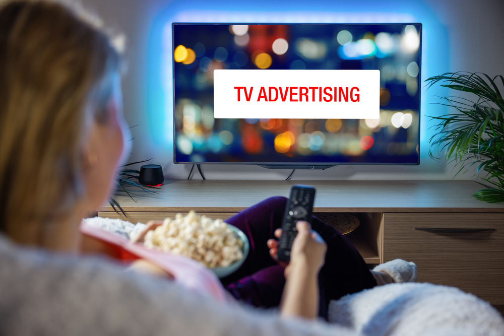 woman looking at ad while watching TV