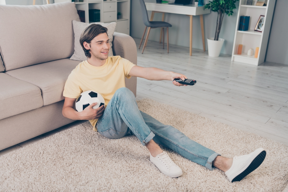 Young man in yellow shirt and sneakers at home