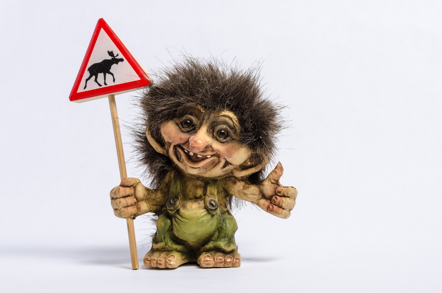 A small norwegian troll hitchhiking and holding a road sign