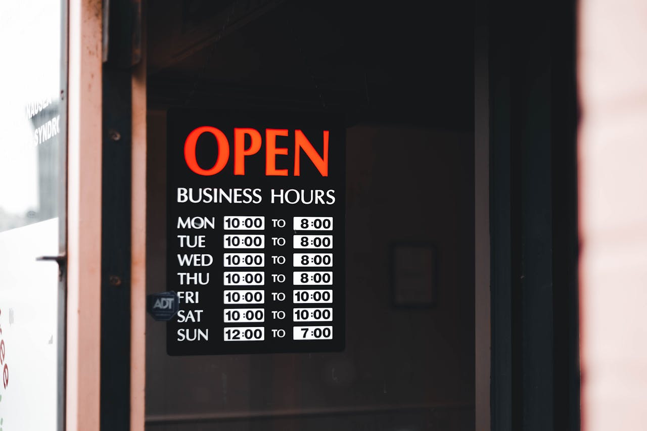 door with black poster for opening hours