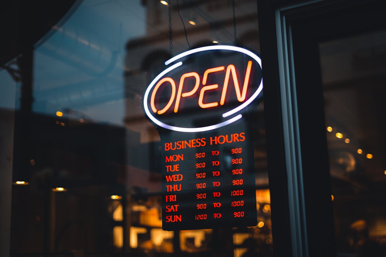 Opening Hours Sign Hanging behind a Store Window