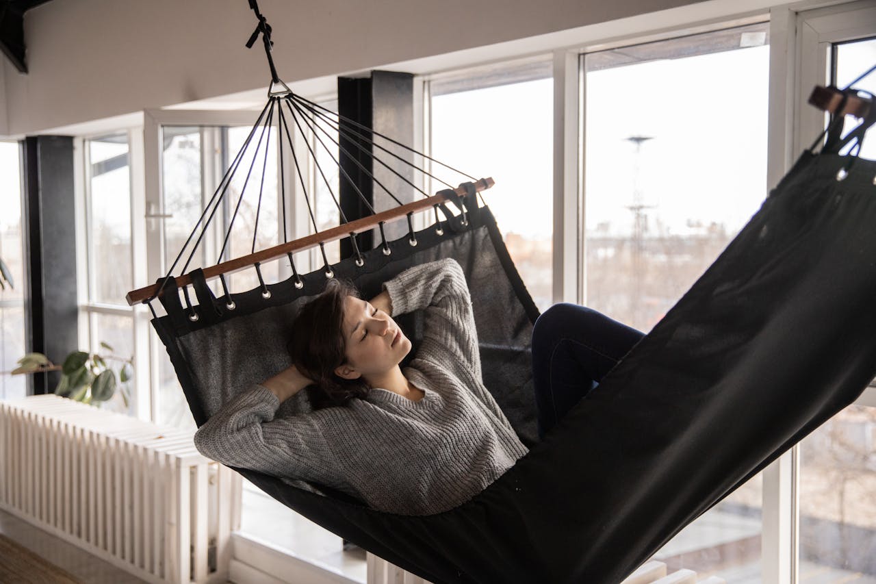 Woman sleeping in cozy hammock in flat