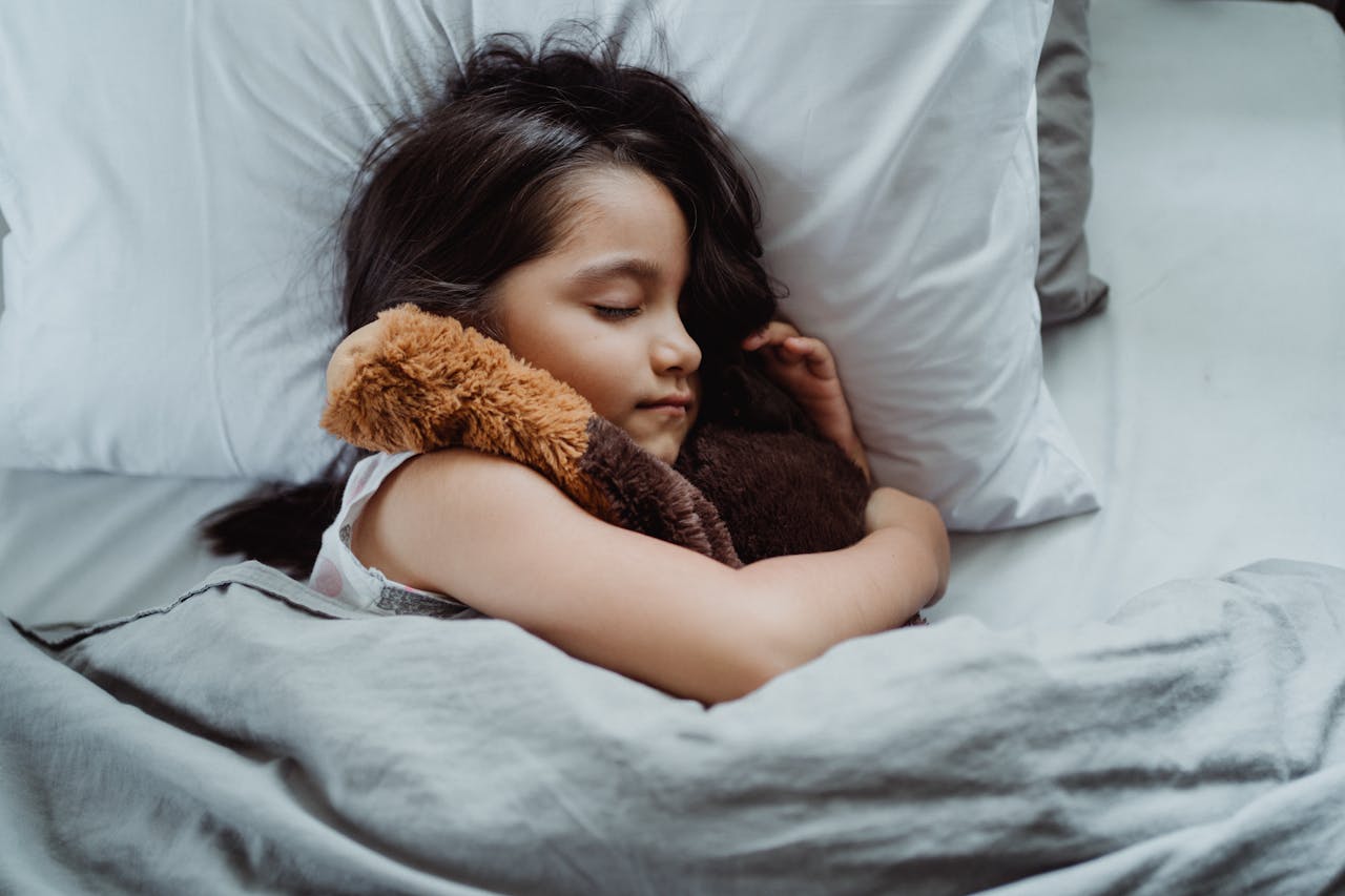 Young girl sleeping with teddy bear