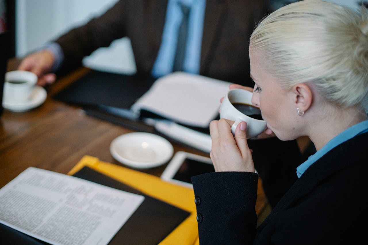 Thoughtful woman drinking coffee during brainstorm
