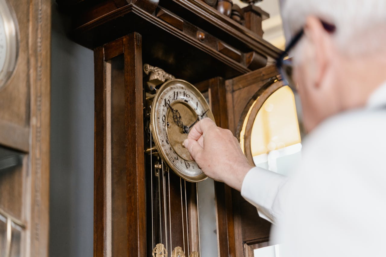 Man Setting Time on a Wall Clock