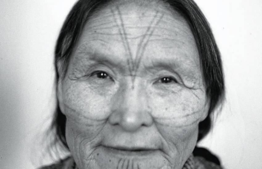 Portrait photograph of a woman with face tattoos