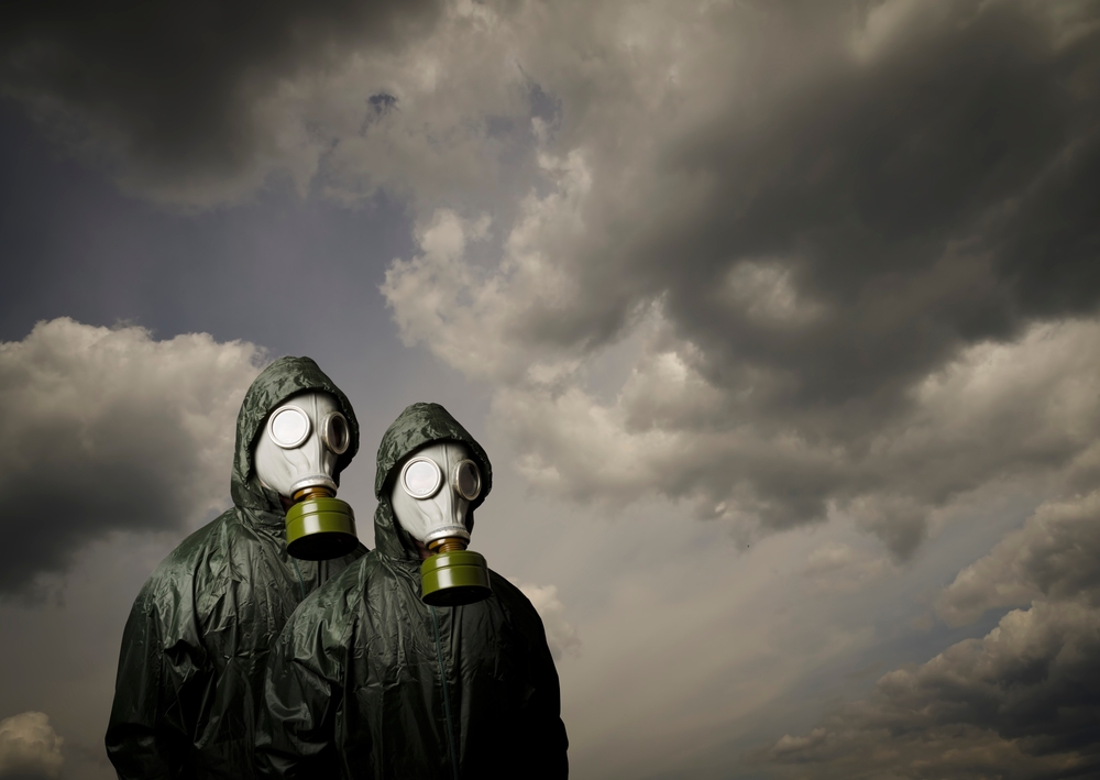 Two people with gas masks and dramatic sky behind