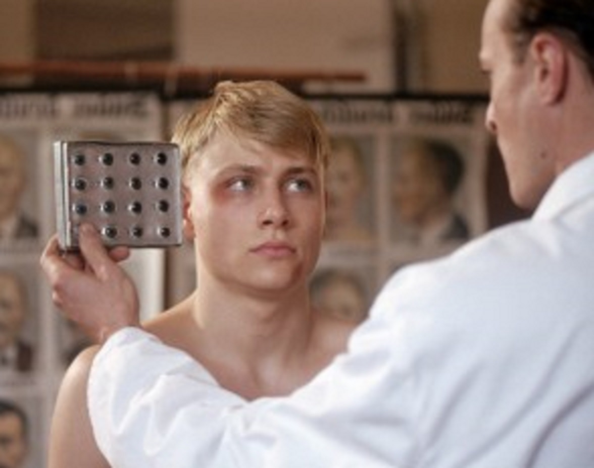 Nazi doctor measures man eye color to see how arian he is.