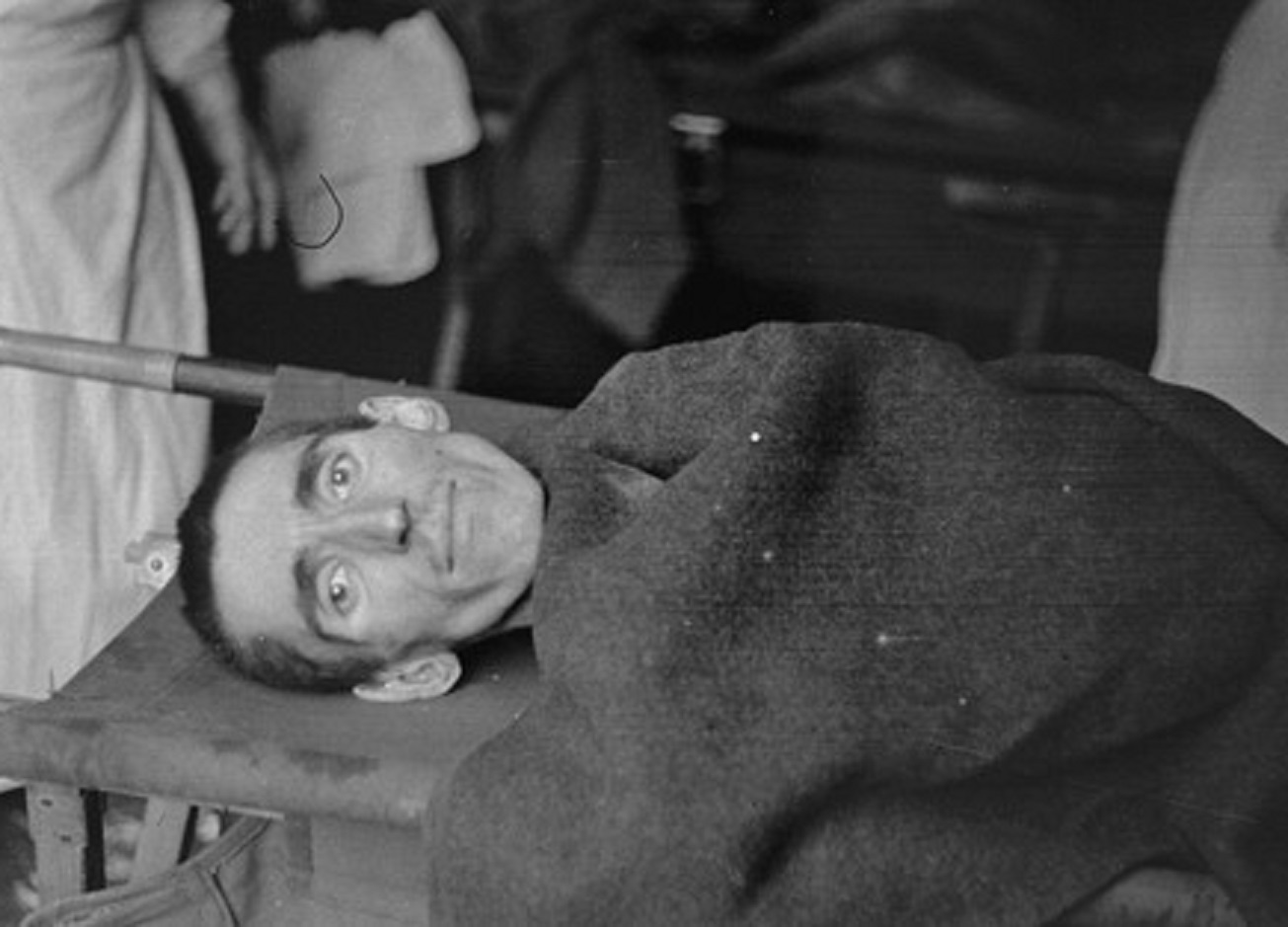 Close-up of a Langenstein survivor being evacuated by stretcher to a hospital. - 1945