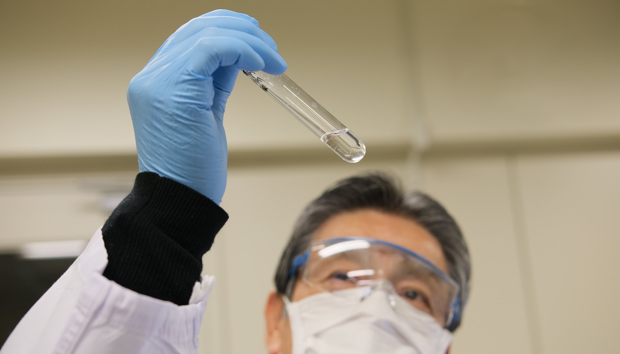 Japanese scientist holding up test vial confirming the result