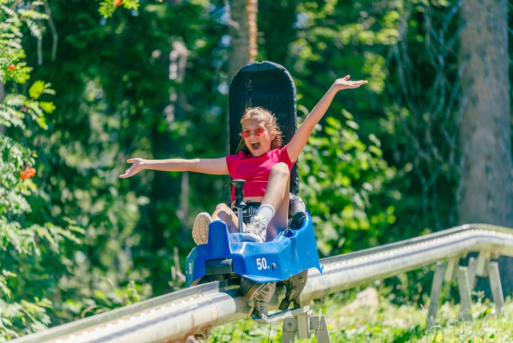 Screaming girl riding mountain roller coaster