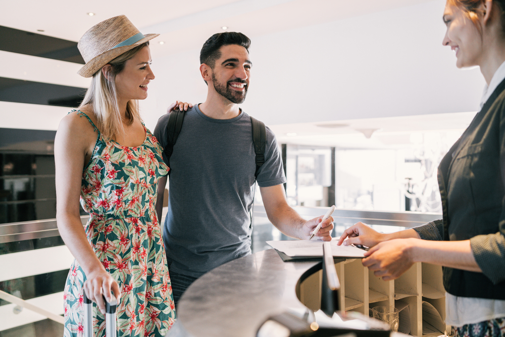 couple doing check-in at hotel reception front desk