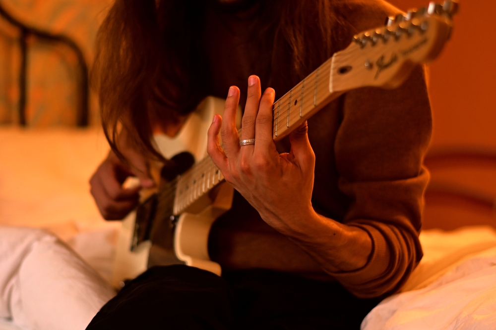 playing a  guitar in hotel room
