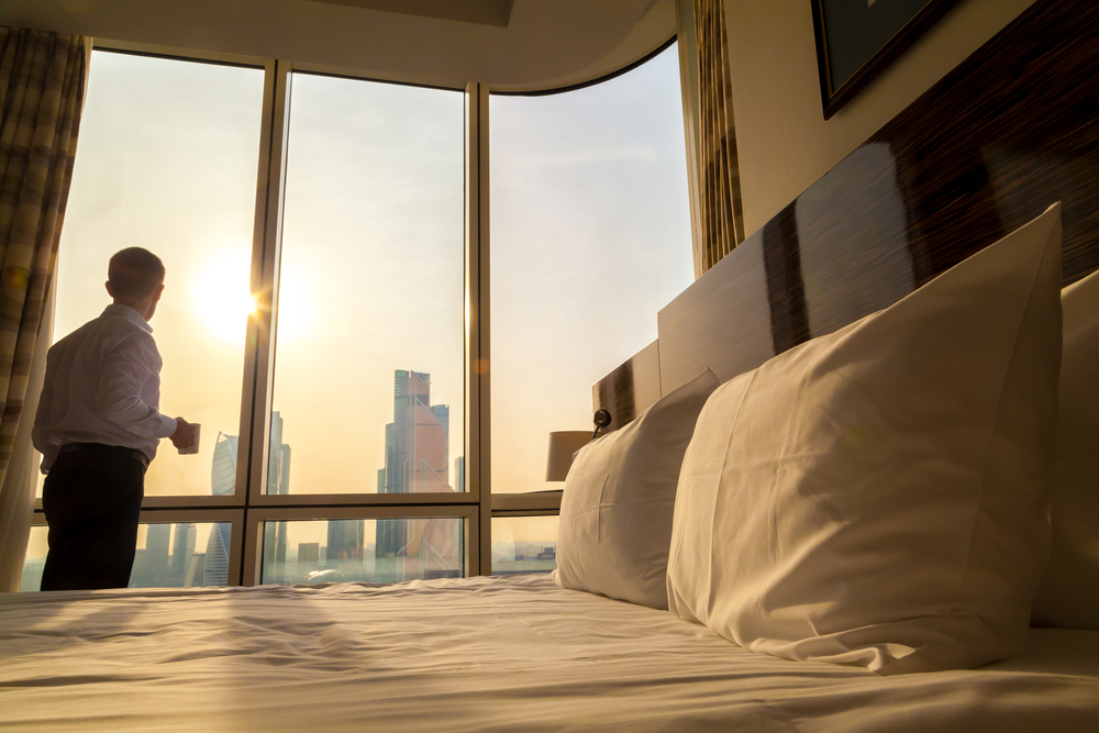 Young businessman with cup of coffee in hotel room