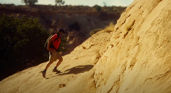 image of a man hiking on rocks
