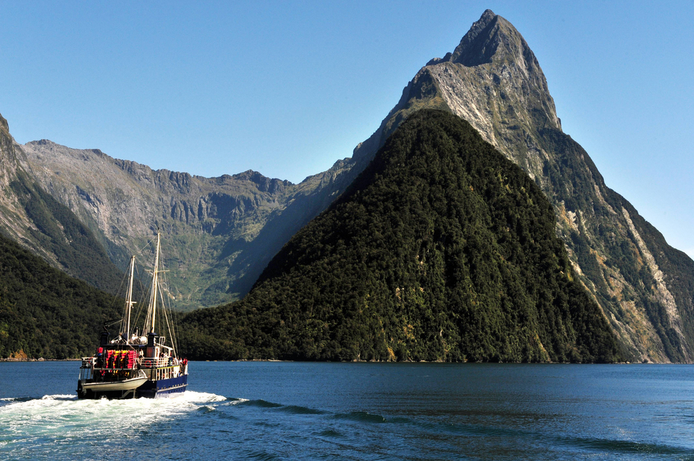 Cruise boat sailing on Milford Sound towards Mitre Peak