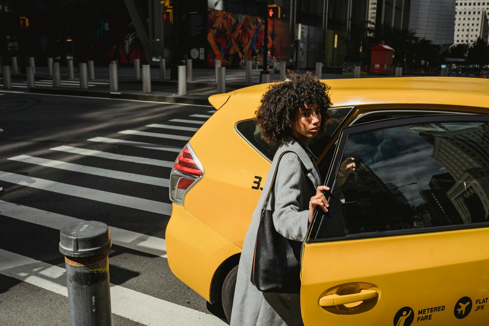 Woman in gray coat getting in taxi