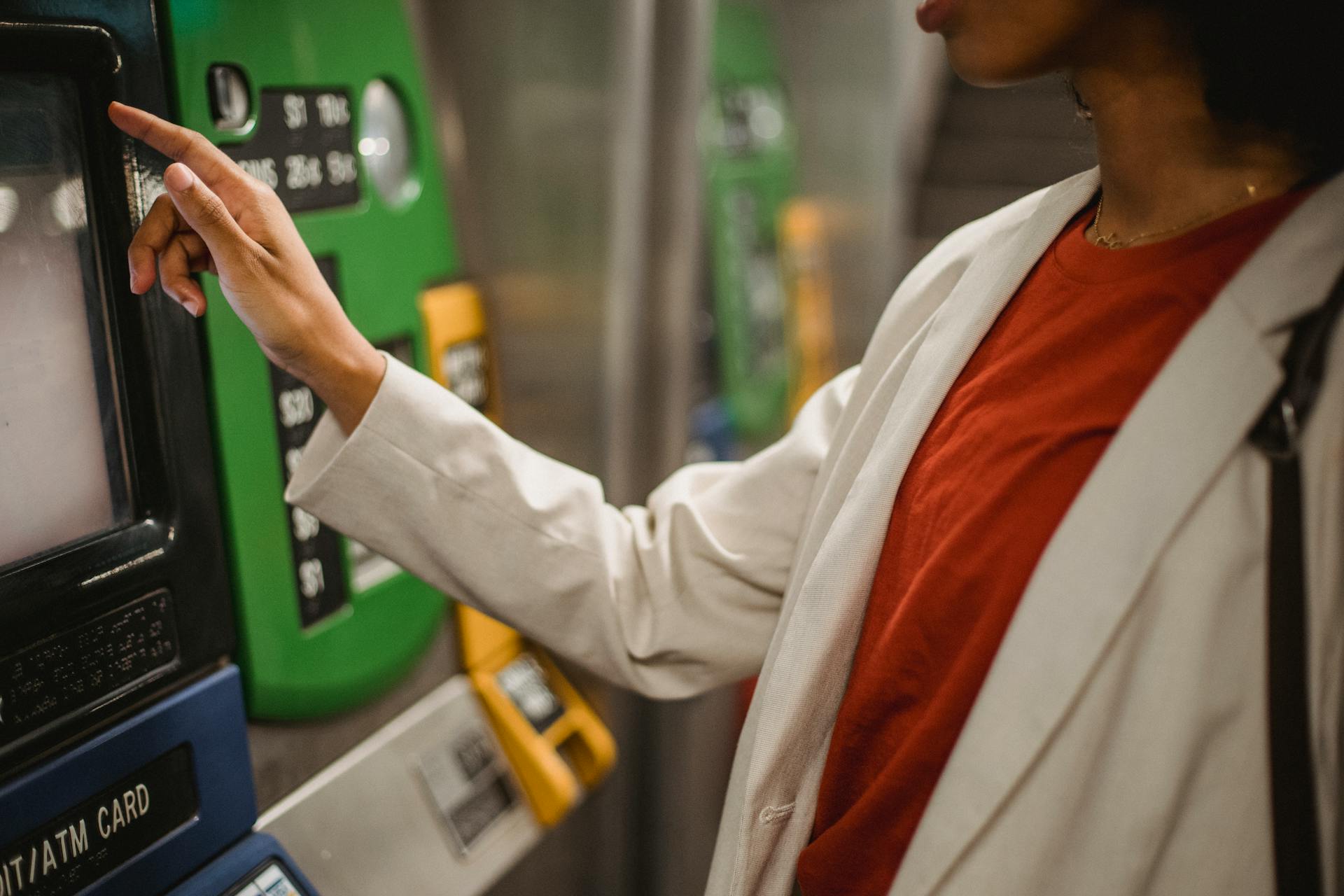 Woman in white jacket using an ATM
