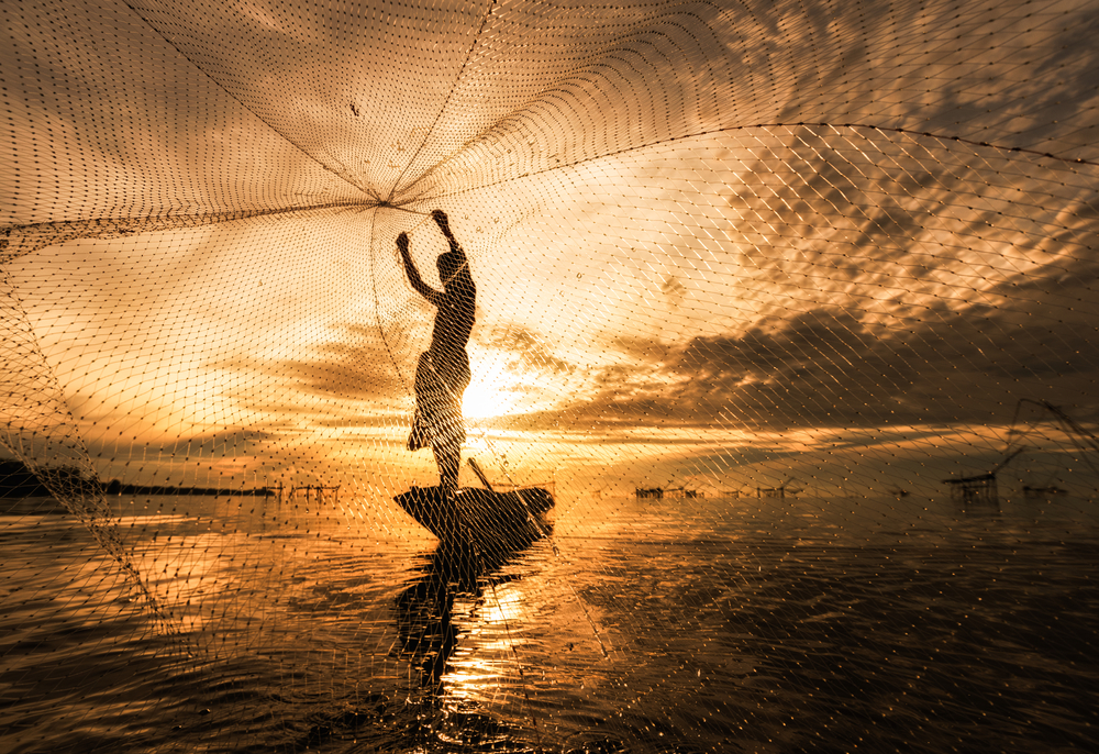 Silhouette of a Fisherman Fishing with Nets