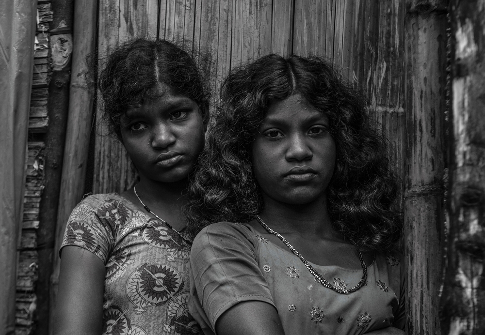 Young indian girls in front of a hut
