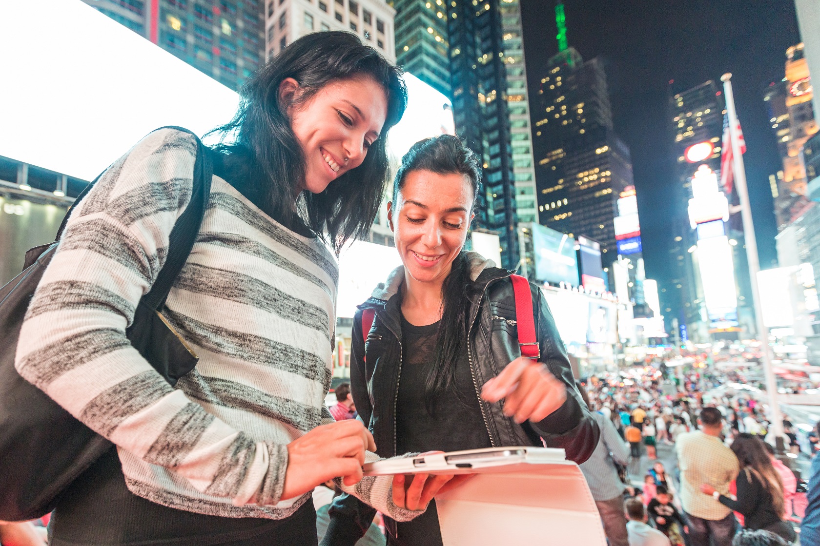 Beautiful young women, tourists in New York city, having fun at night in the city