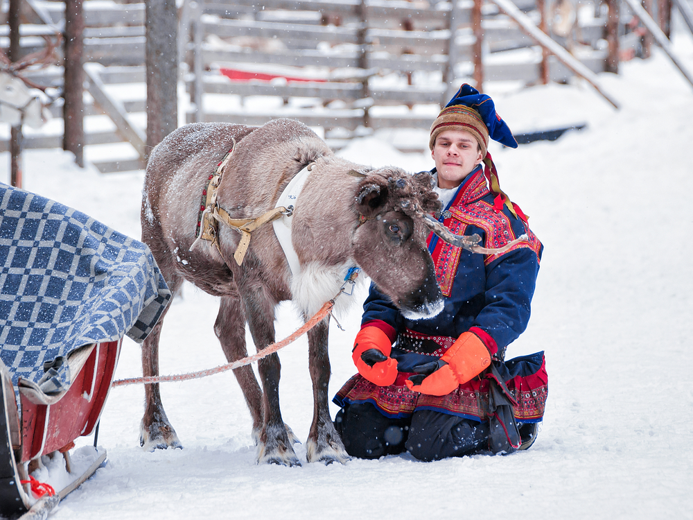 Man in traditional Sami costume and the reindeer
