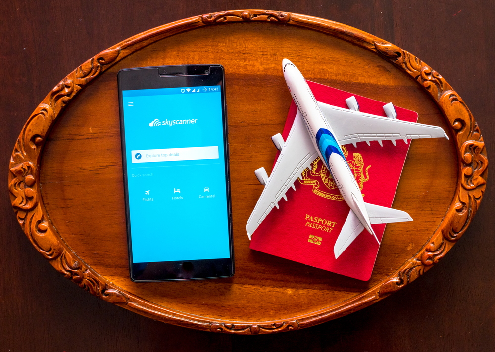 image of Skyscanner app and airplane concept