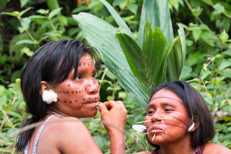 Portrait photo of two Yanomami women with traditional face decoration
