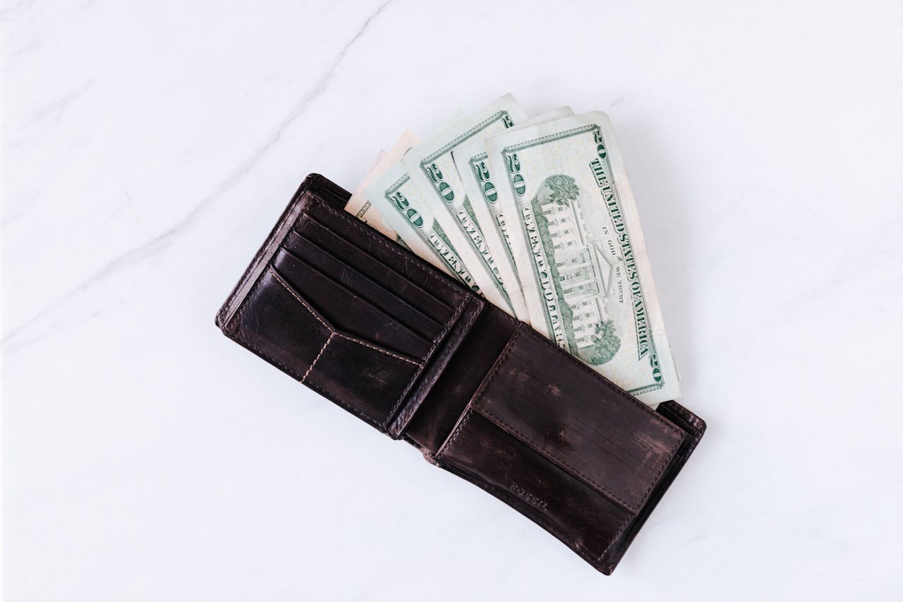 Wallet with pile of American paper dollars